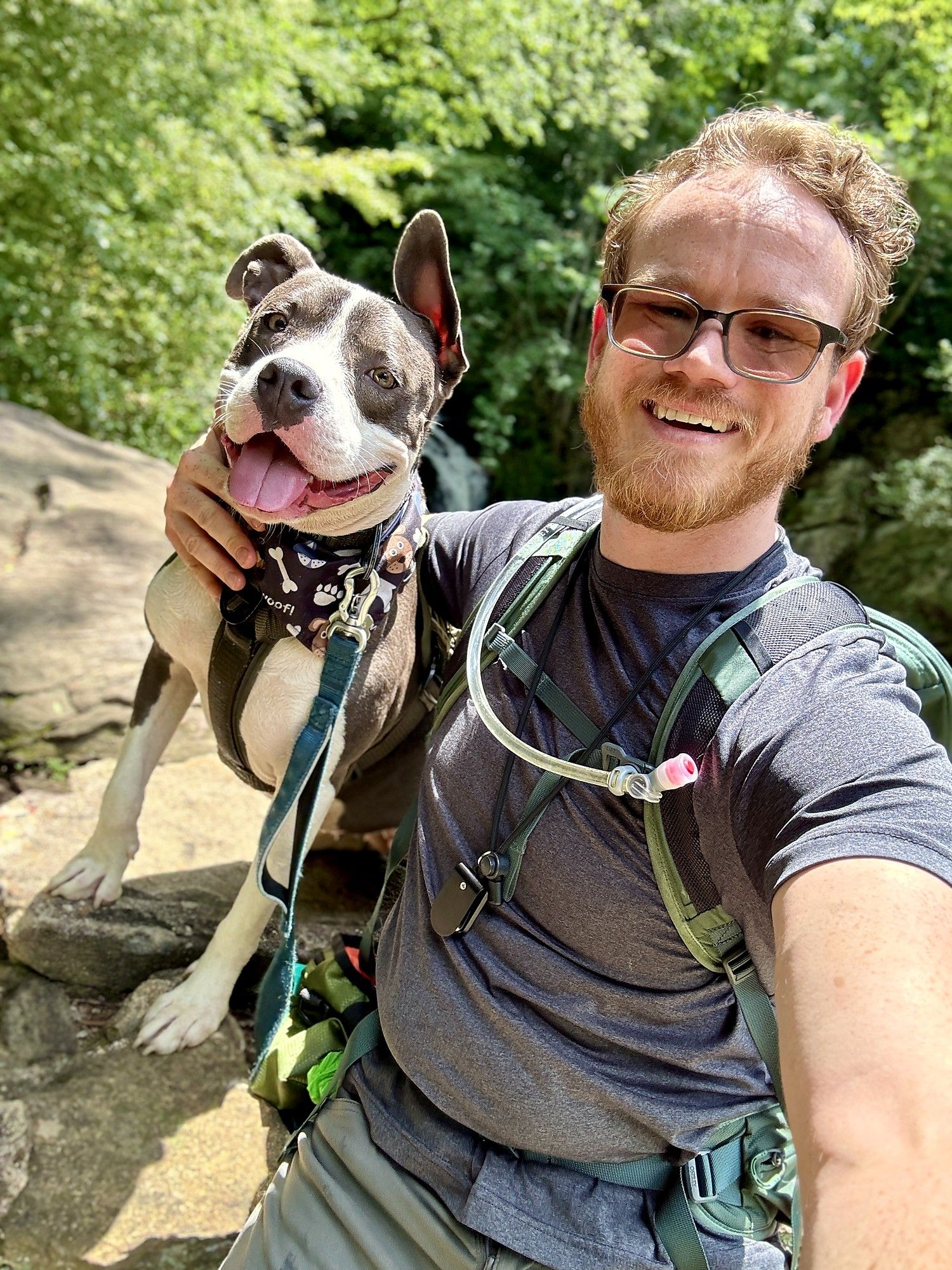 Phillip Greene on a trail with Lucky the pit bull leaning in close, both smiling